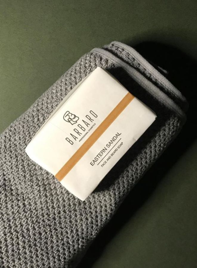 Barbara Eastern Sandal soap on a textured gray surface with a green background