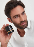 Man holding a Barbaro hair wax against a white background