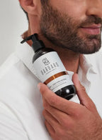 Man holding a bottle of Barbaro hair care product against a white background
