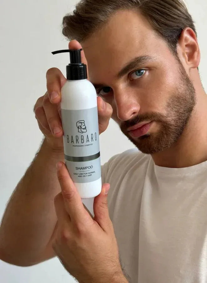 Man holding a bottle of Barbaro shampoo against a plain background