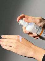 Hand applying a white cream from a Barbaro bottle on a gray background
