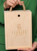 Wooden box with 'Barbaro' branding held by a person against a green background