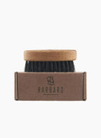 Barbaro brush with wooden handle and black bristles on a cardboard box labeled 'BARBARO' against a white background.