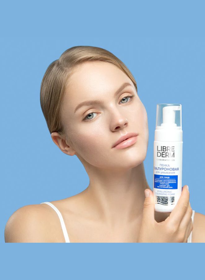 Woman holding a Librederm product against a blue background