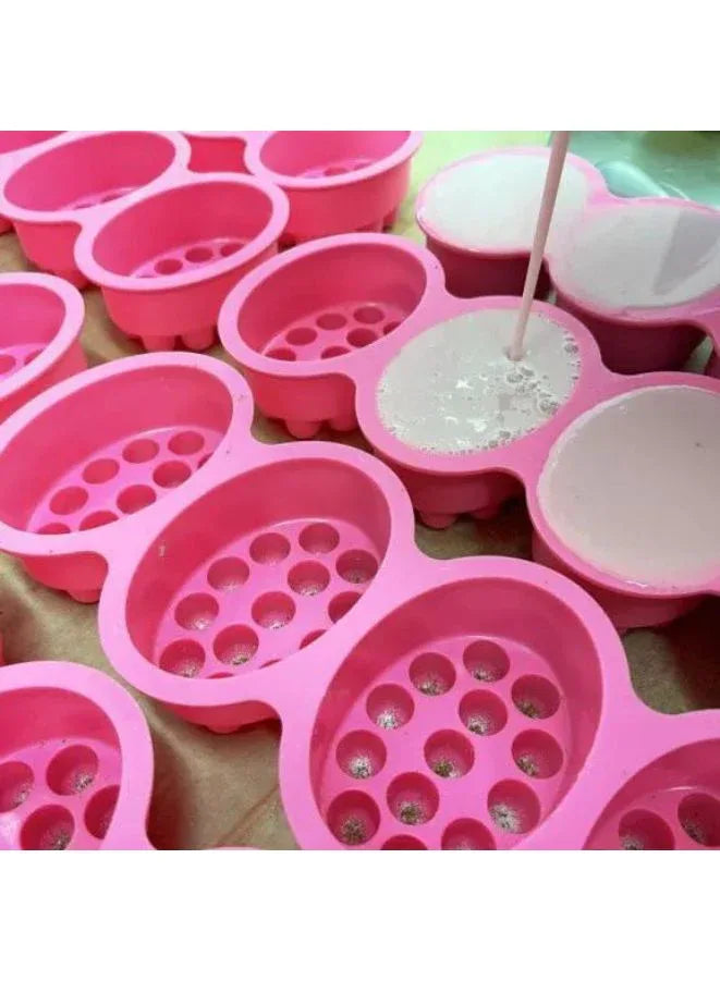 Pink silicone mold with multiple compartments on a green surface