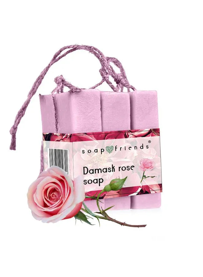 A set of pink soap bars tied with a string, labeled as 'Damask rose soap', with a rose flower in the foreground.