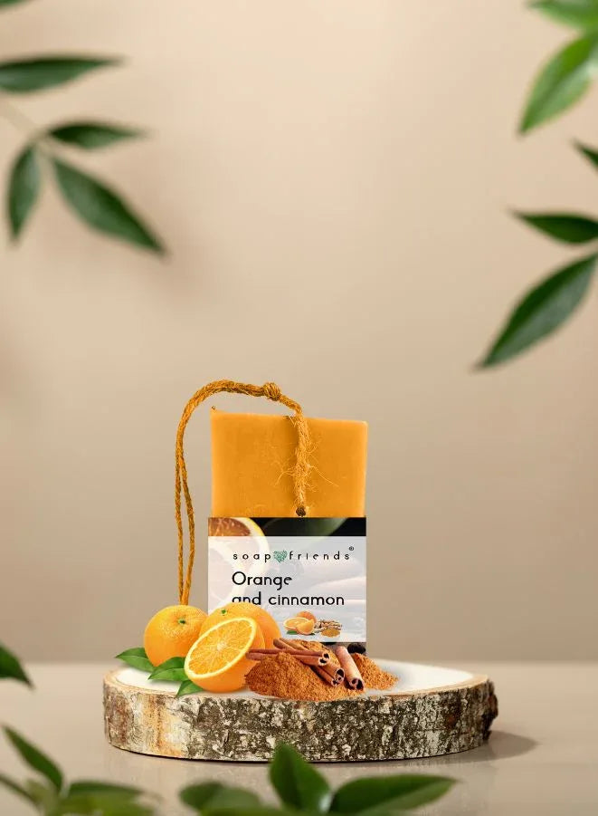 Bar of soap with 'Orange and cinnamon' scent on a wooden stand with decorative elements.